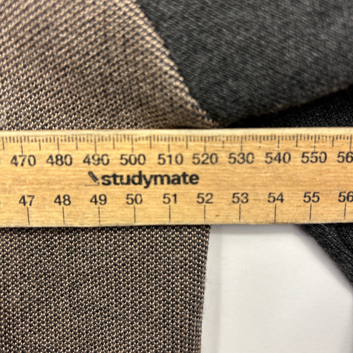 Grey and beige fabric texture detail view with measurement ruler