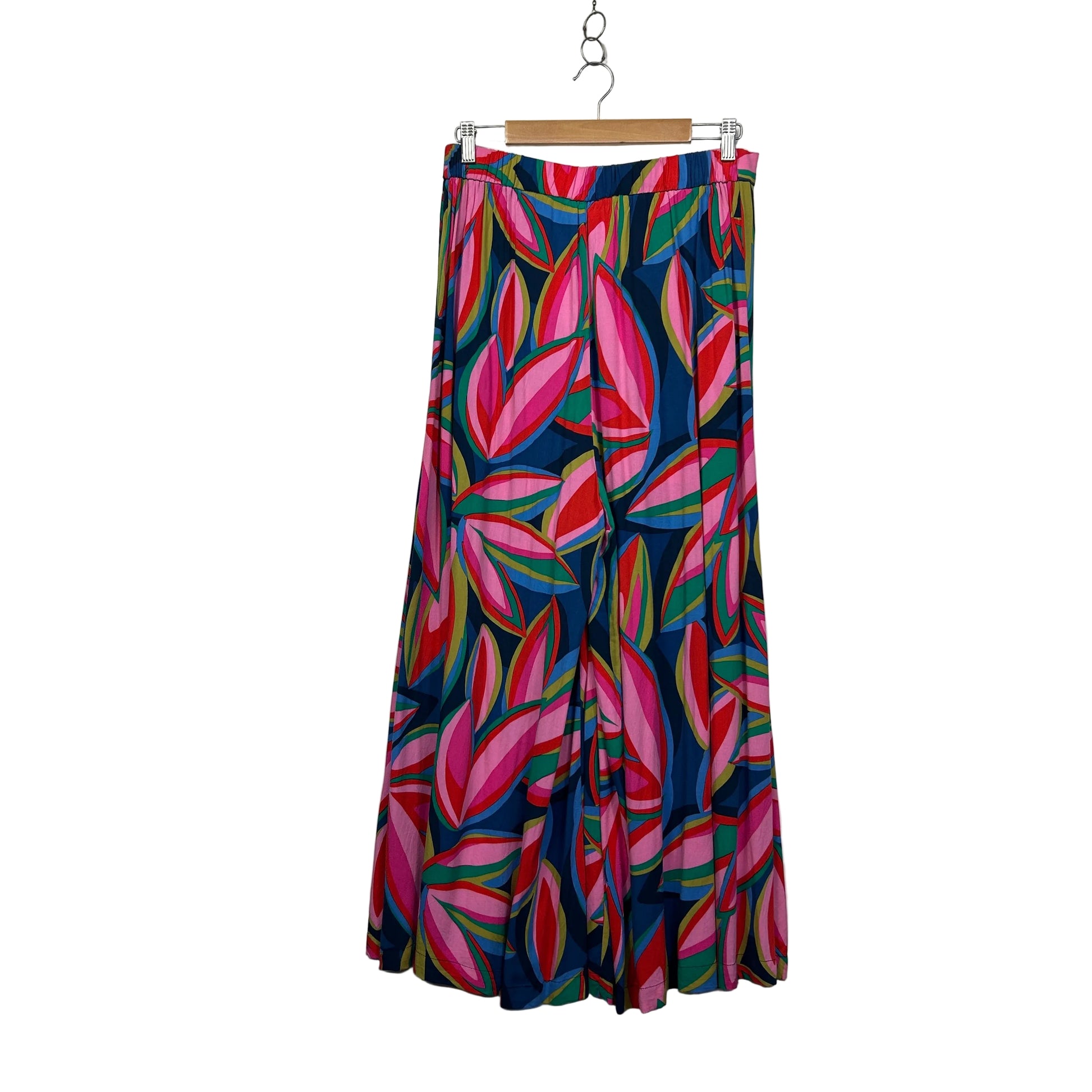 Colorful leaf-patterned skirt on a hanger against a plain background