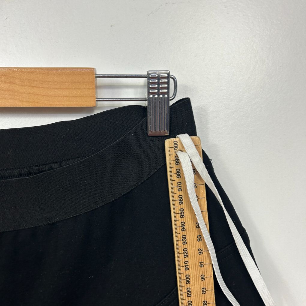 Black pants front view on hanger with measuring tape