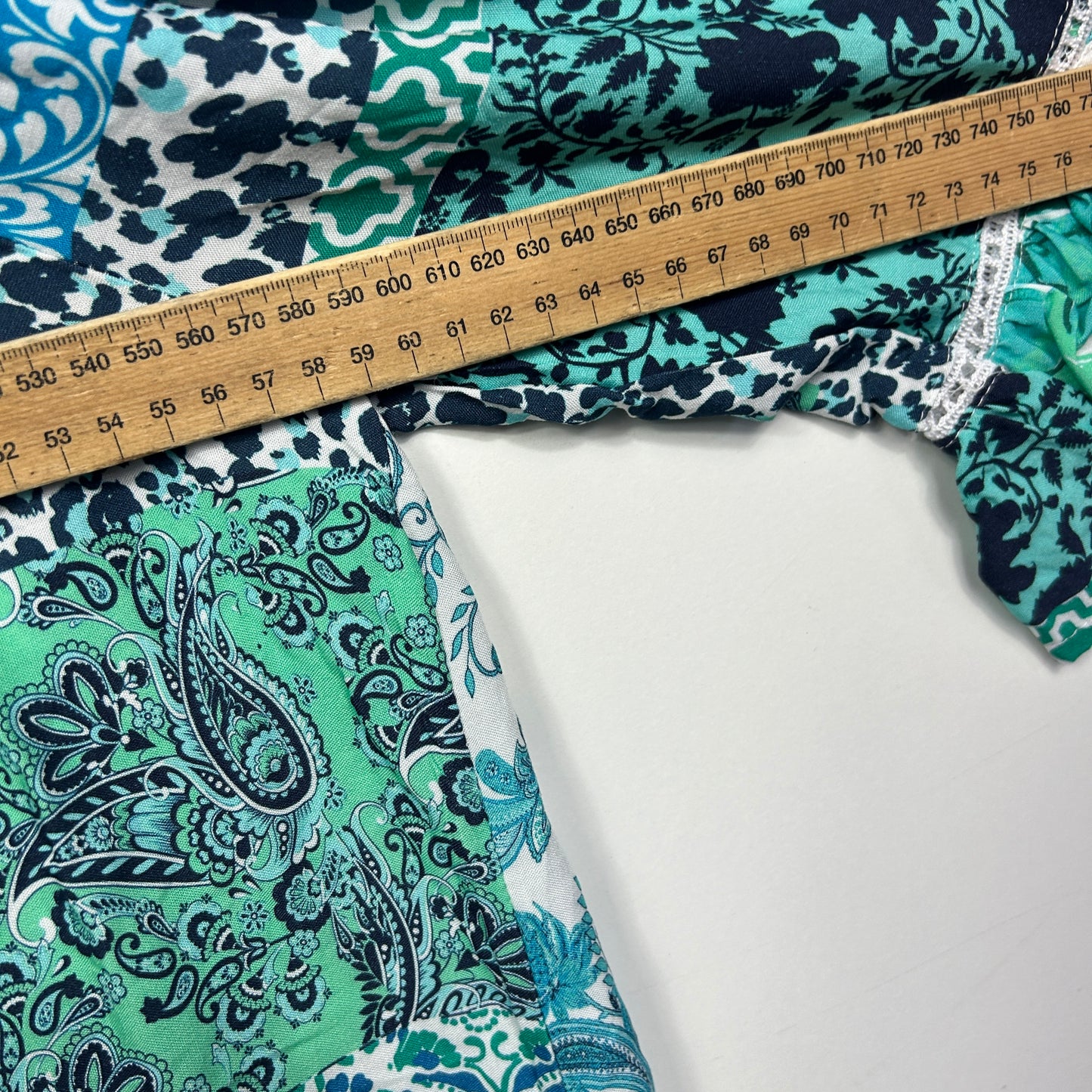 Green and navy patterned fabric with measuring tape detail view