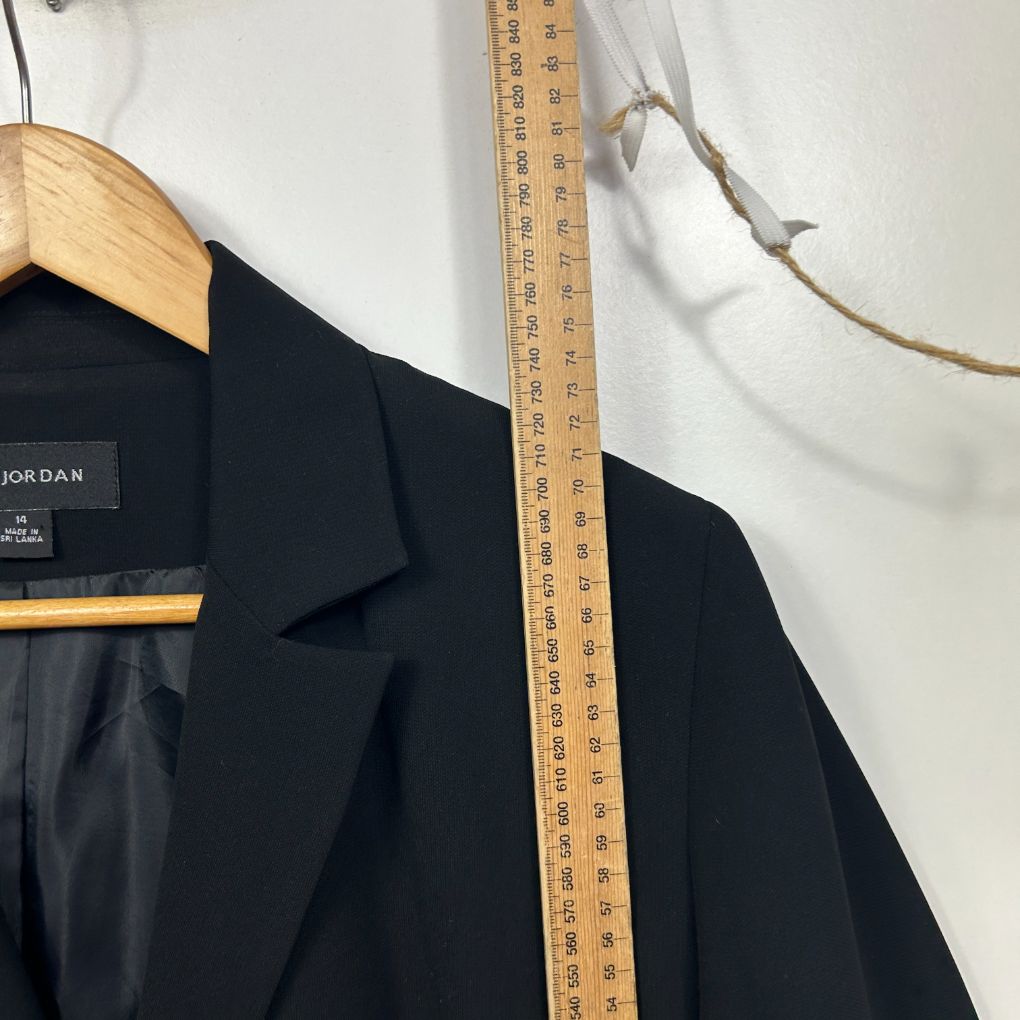 Black blazer front view with wooden hanger and measuring tape