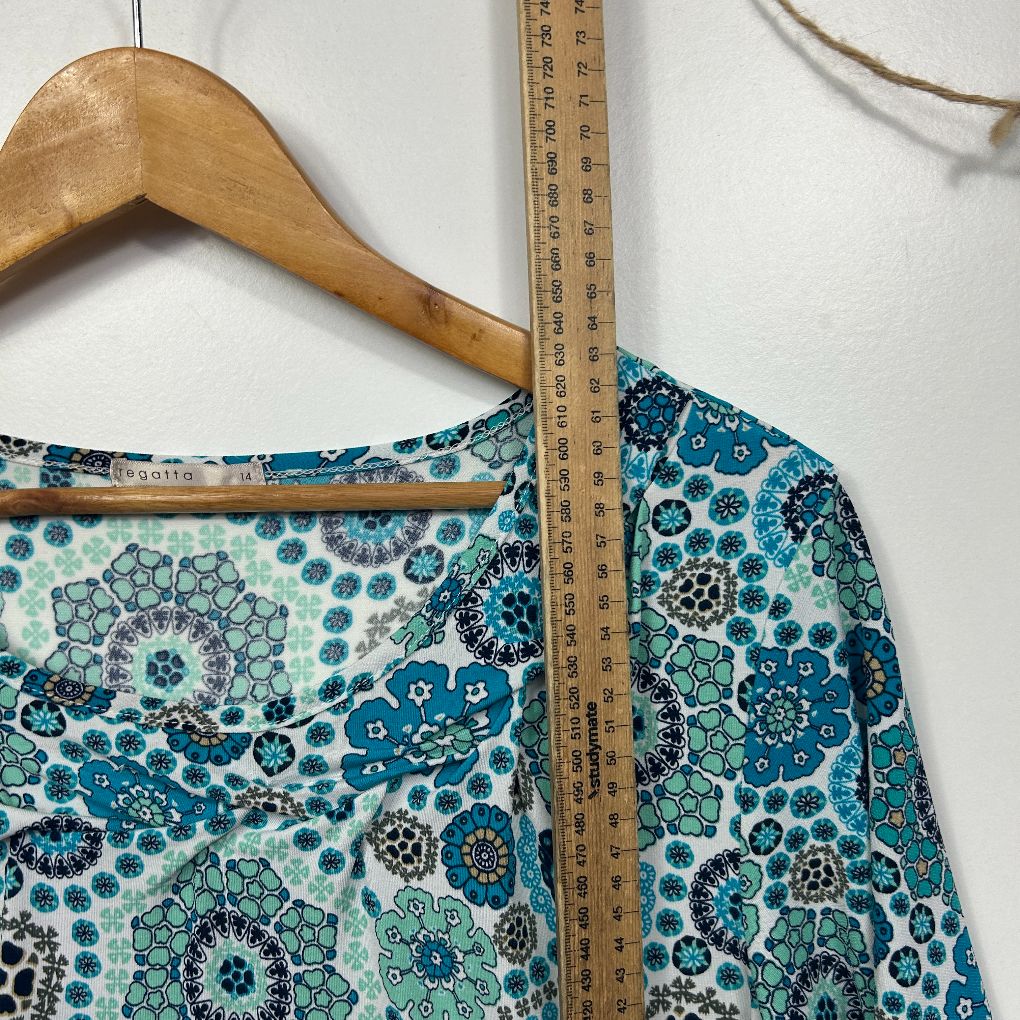 Blue floral print top detail view with measuring tape