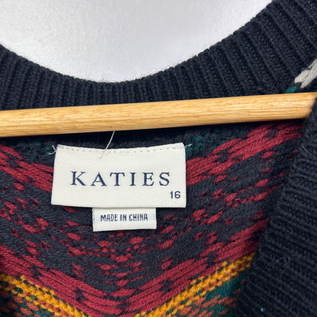 Navy wool sweater with red and gold geometric pattern detail view