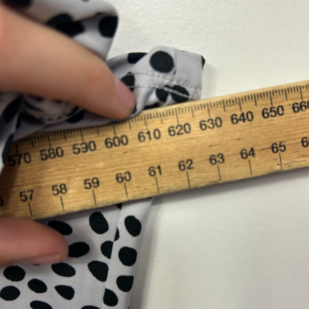 White fabric with black polka dots being measured with a ruler detail view