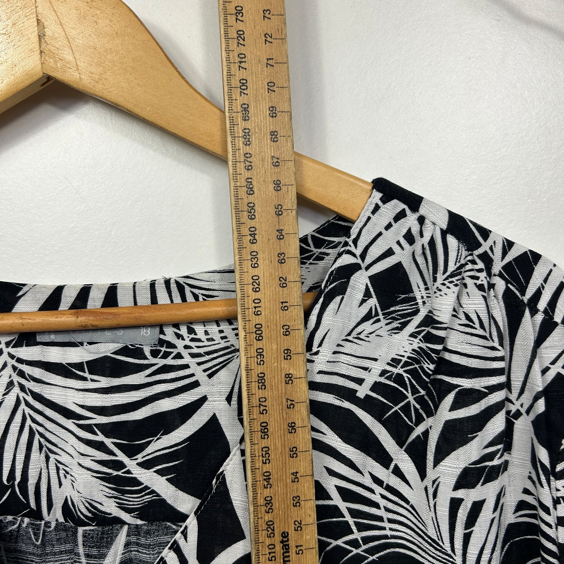 Black and white tropical print shorts detail view with measuring tape