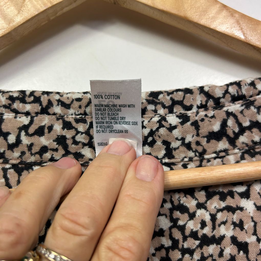 Black and cream animal print fabric detail view with care label
