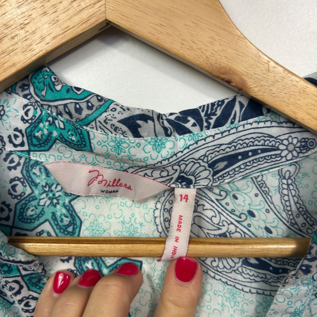 Paisley patterned garment detail view with wooden hanger and size label