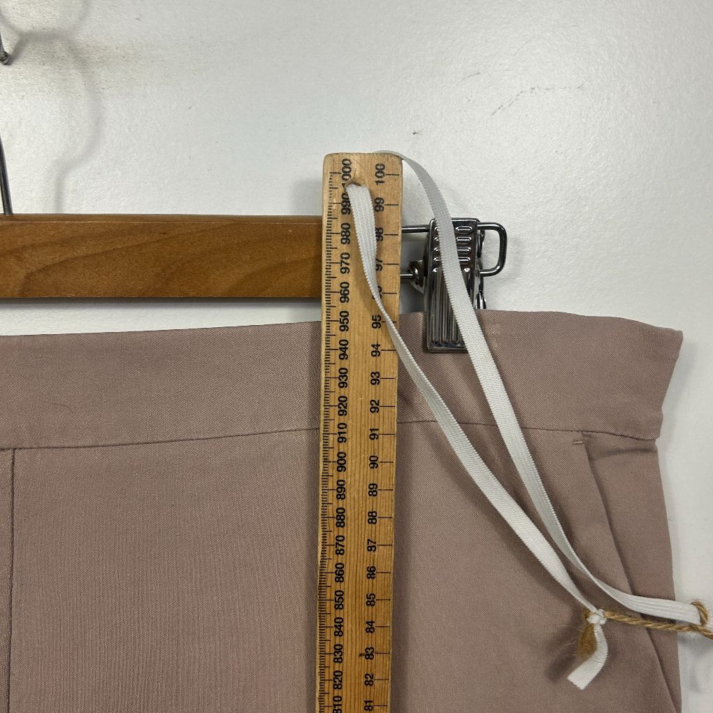 Beige pants detail view with measuring tape