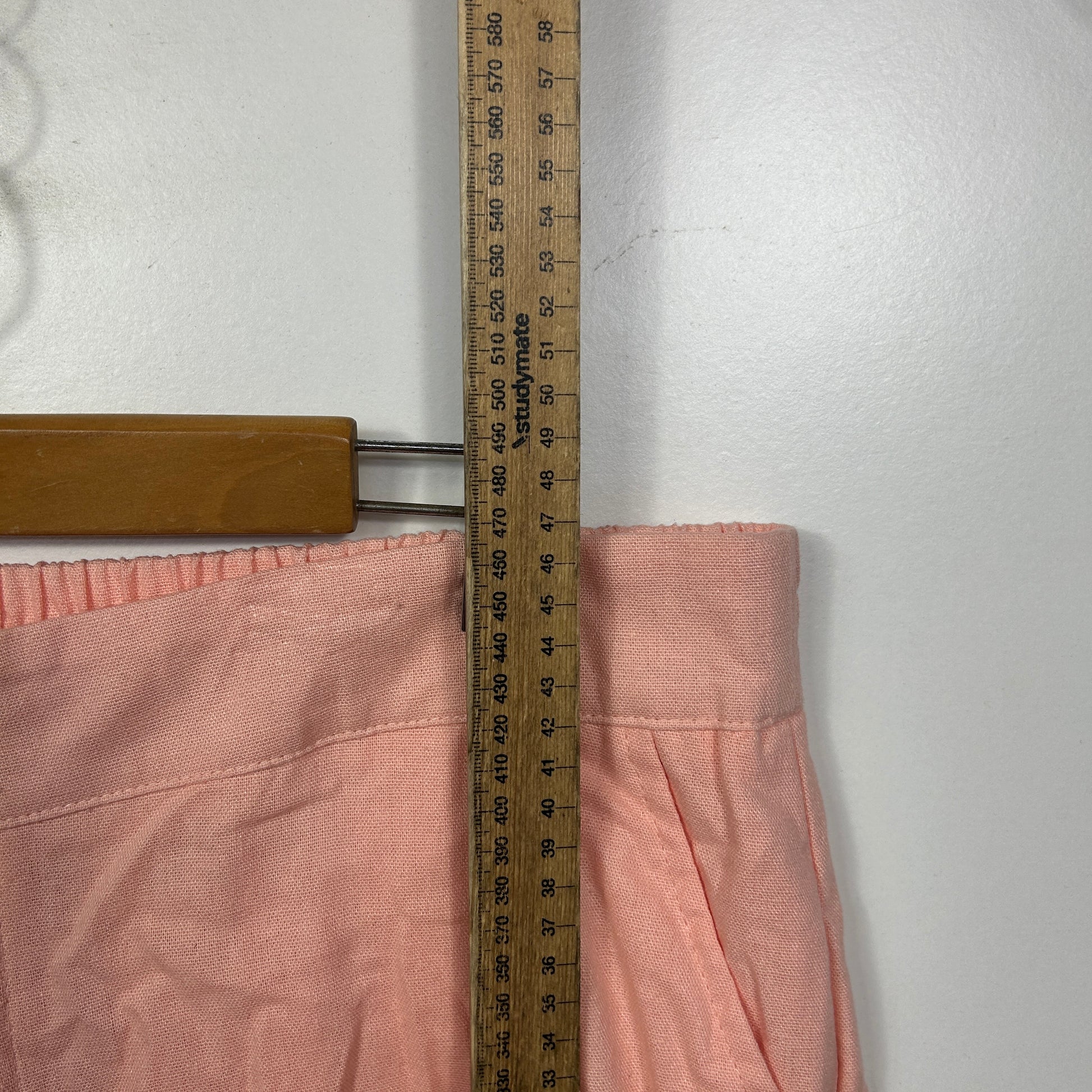 Pink pants waistband detail view with measuring tape