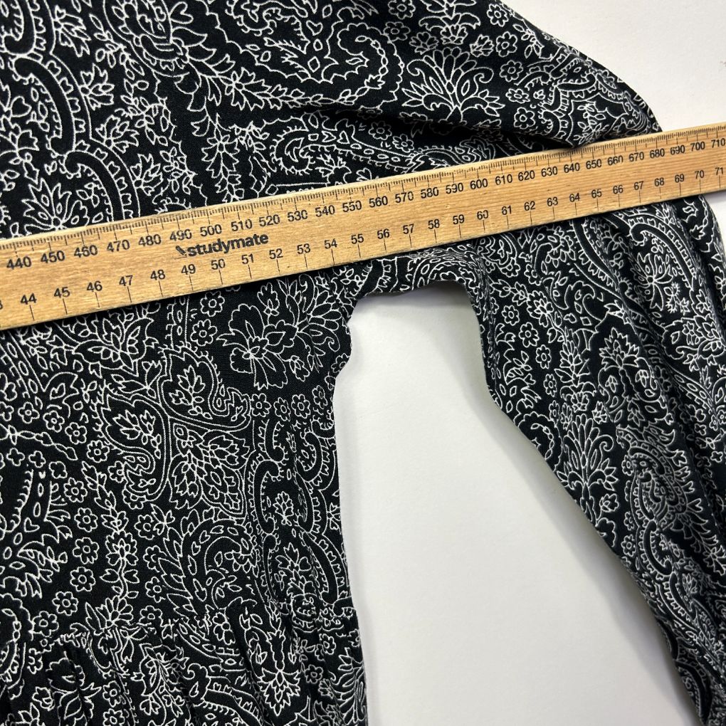 Black and white floral patterned fabric with measuring tape detail view