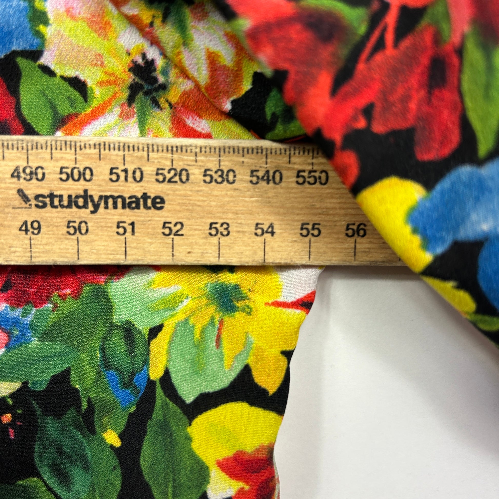 Colorful floral fabric detail view with ruler measurement