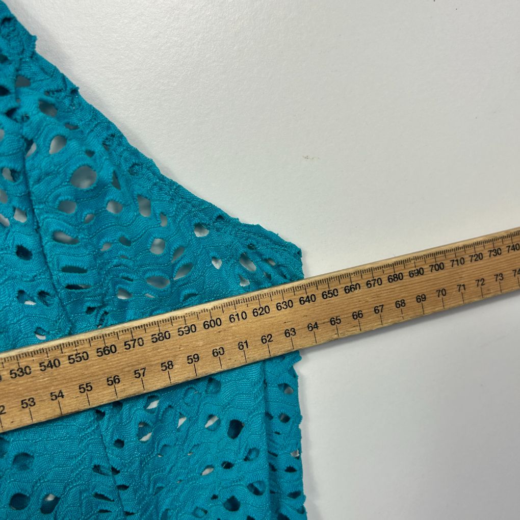 Blue lace fabric detail view with measuring tape