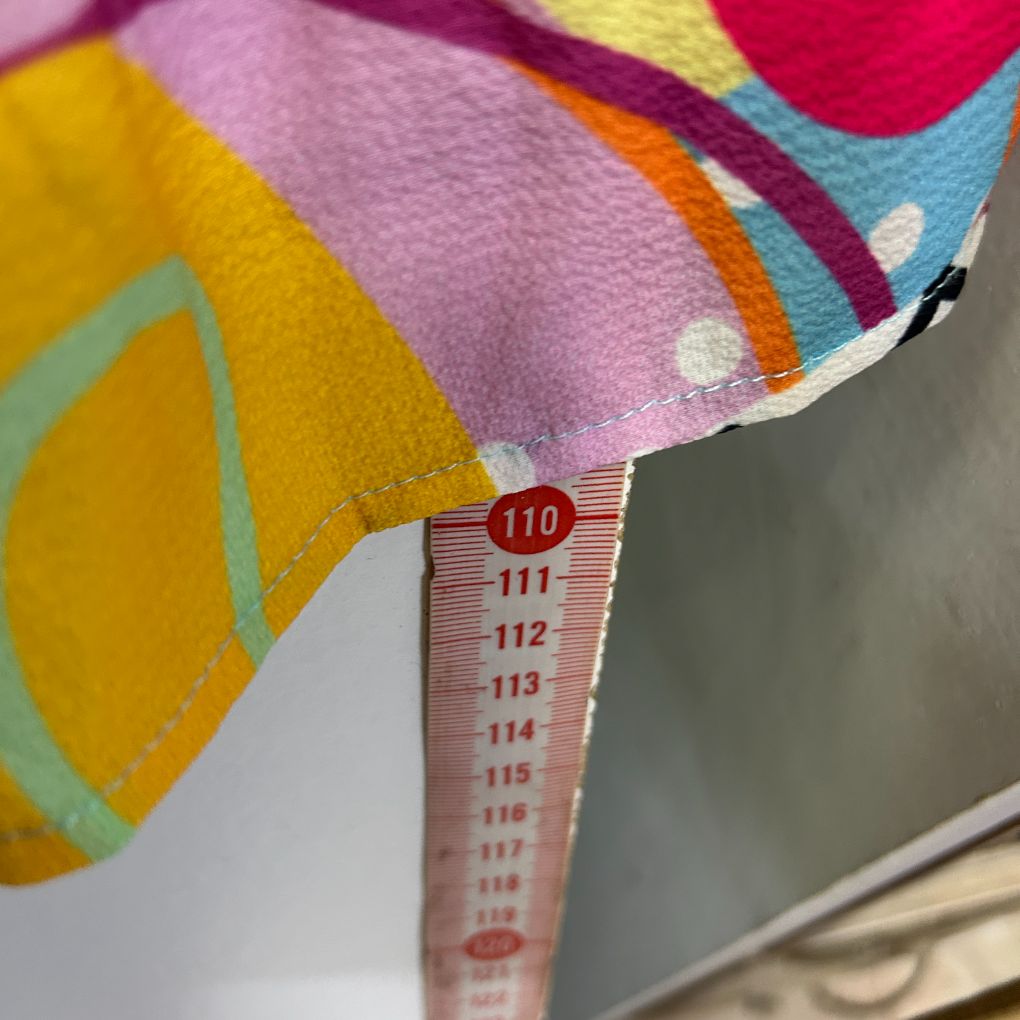 Colorful patterned fabric detail view with measurement label