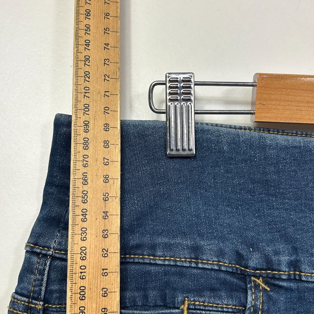 Dark blue denim jeans with measuring tape detail view