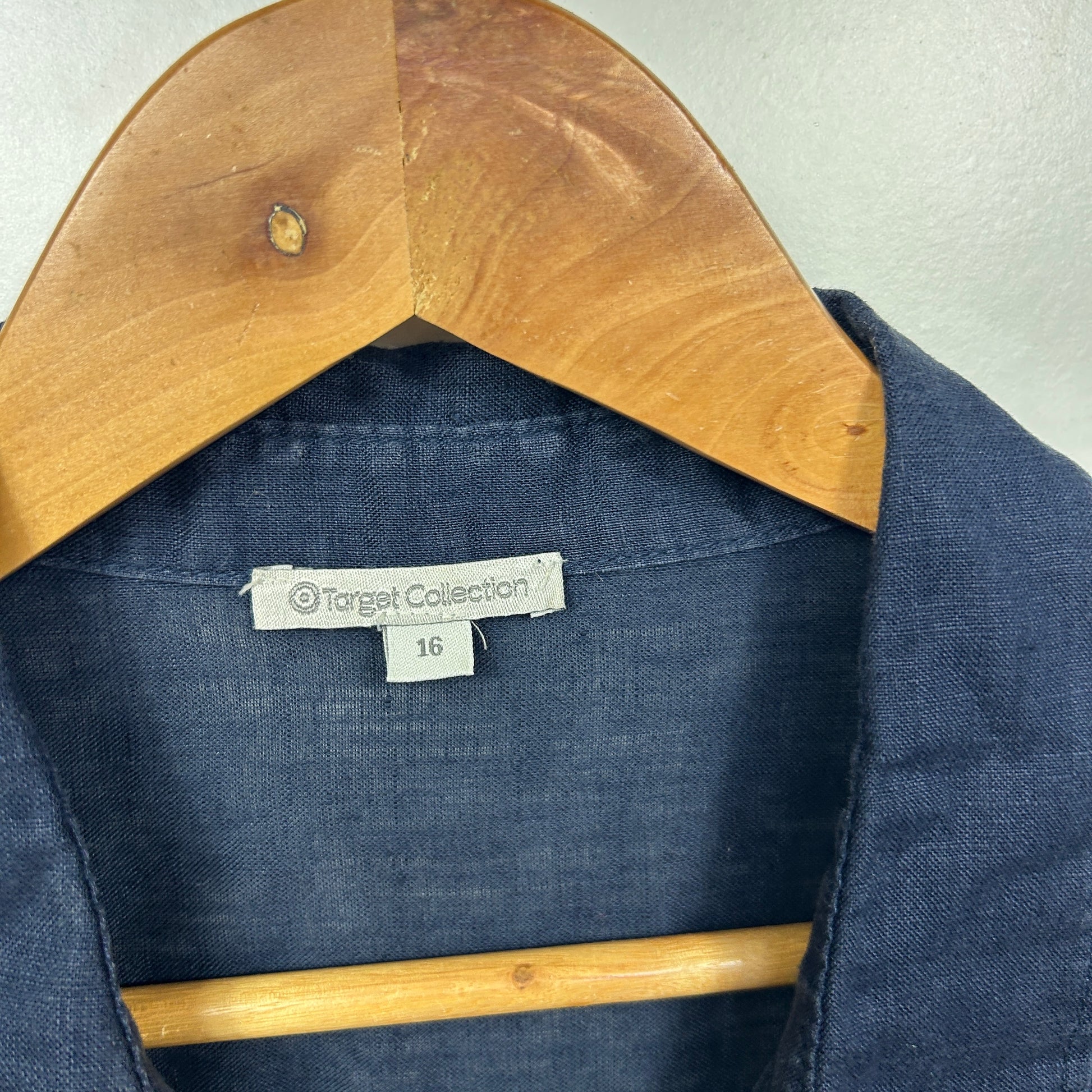 Navy blue shirt front view on wooden hanger