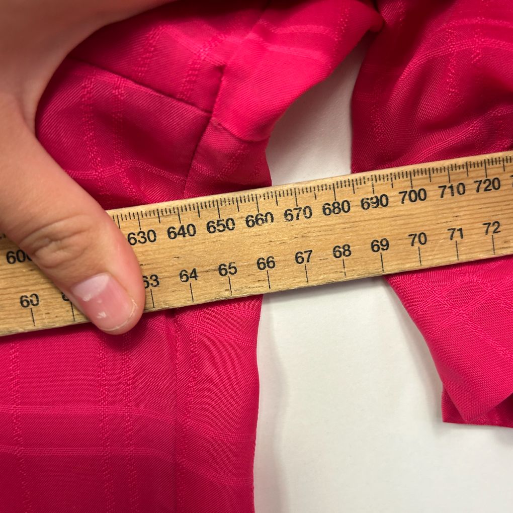 Pink swimsuit detail view with measuring tape