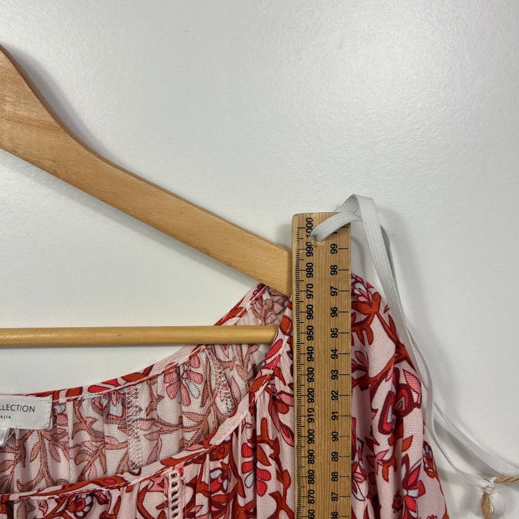 Red and white floral dress detail view with measurement ruler