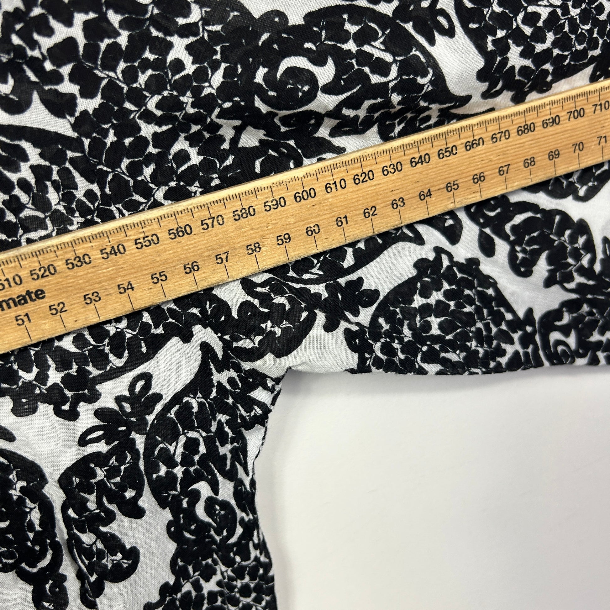 Black and white floral print fabric detail view with measuring tape