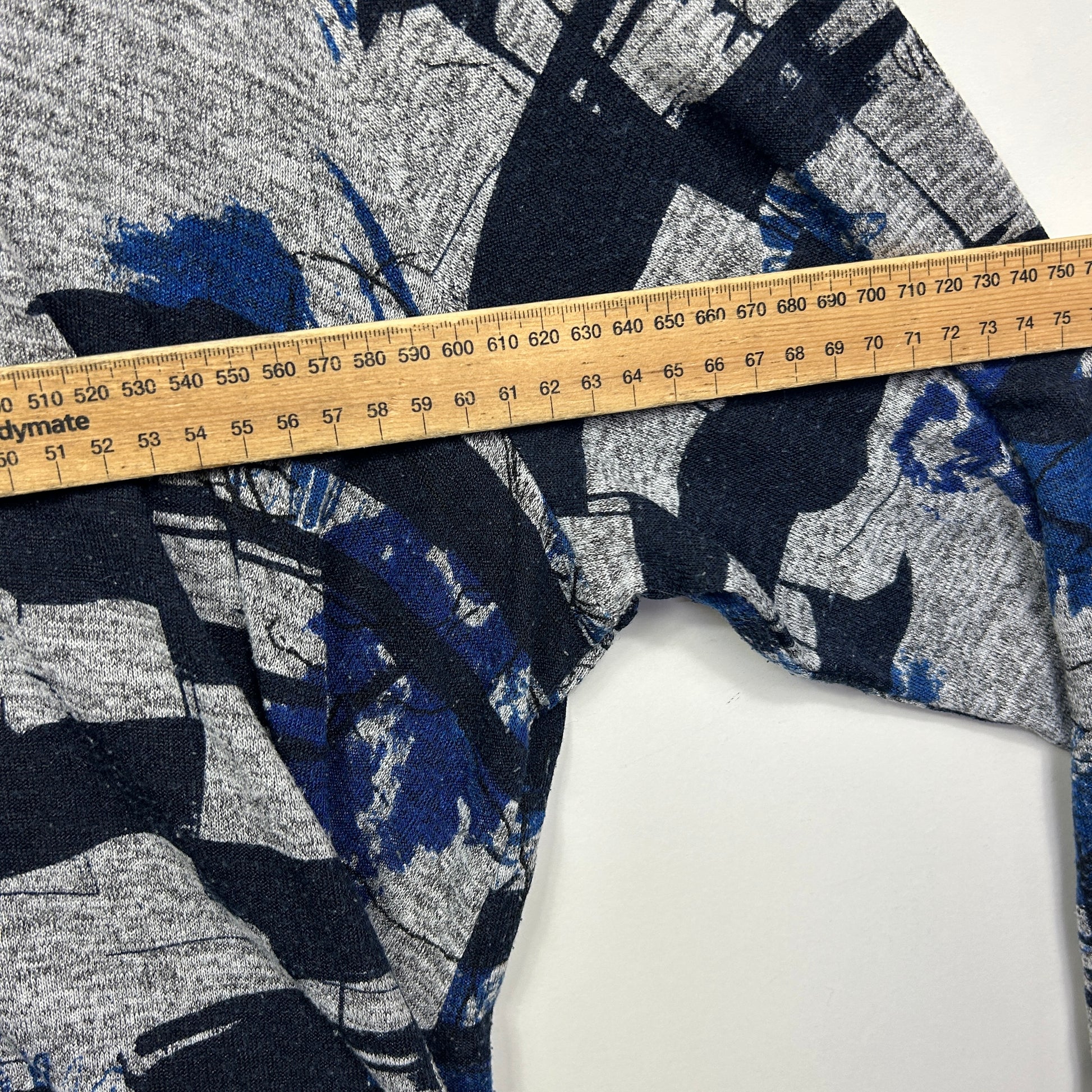 Navy and grey patterned knit top detail view with measuring tape