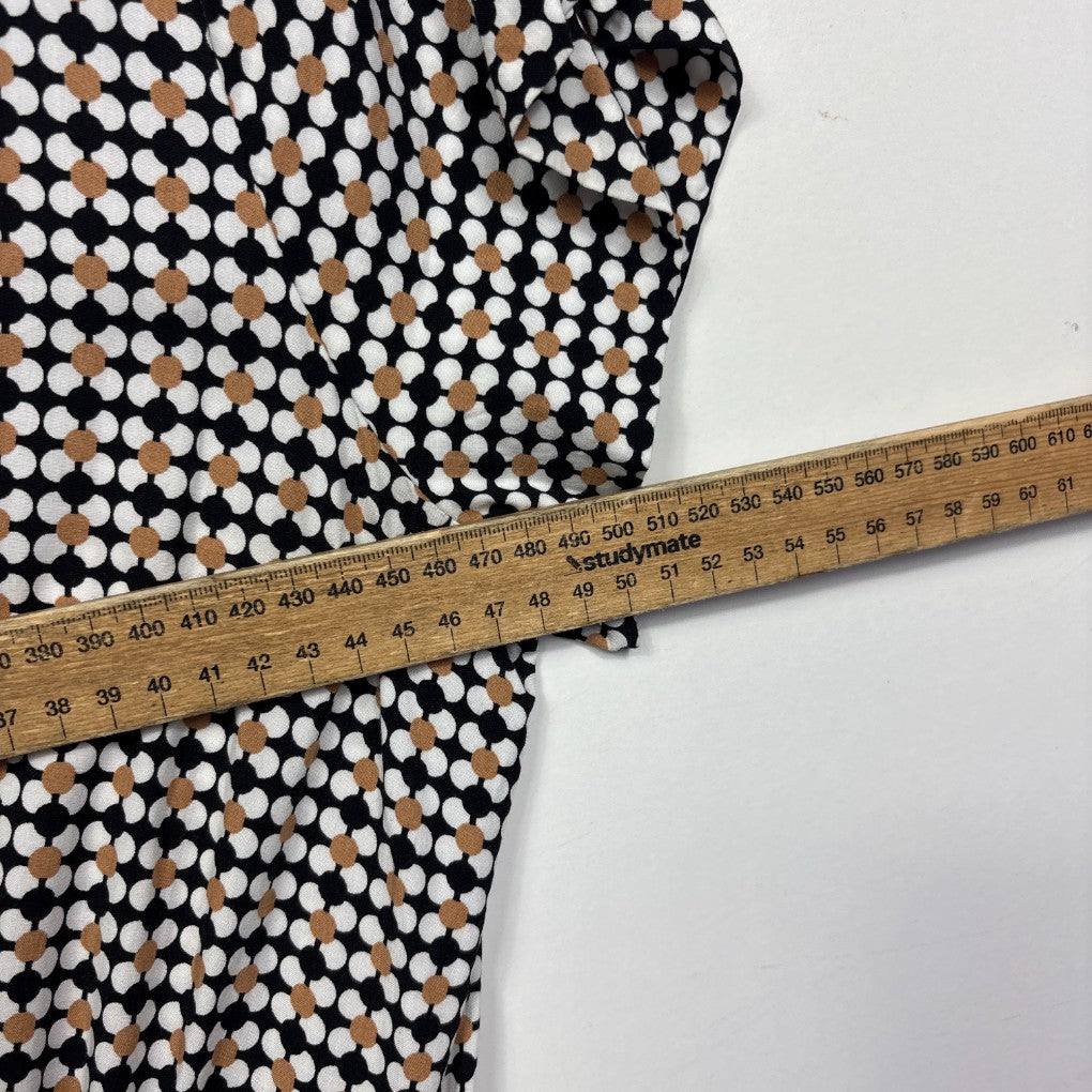 Black and white polka dot fabric detail view with measuring tape