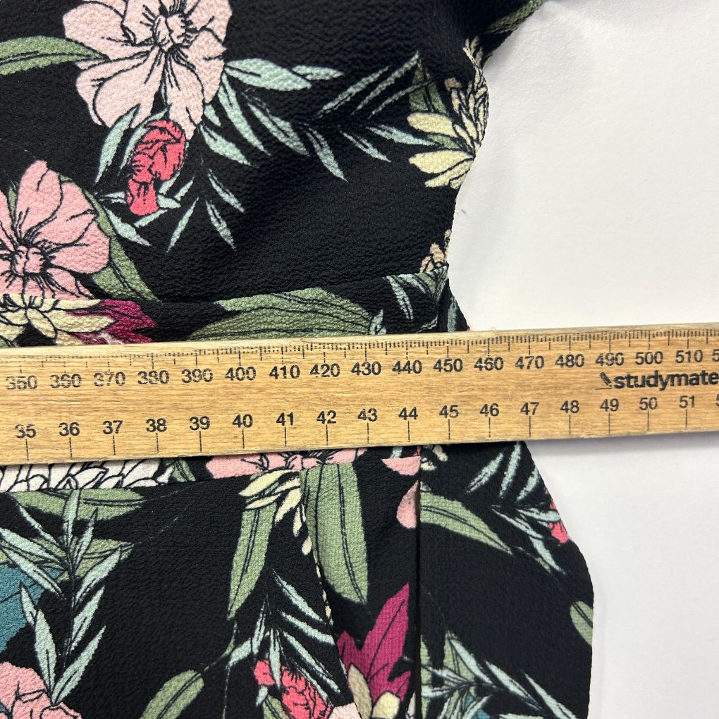 Black floral print dress detail view with measuring tape