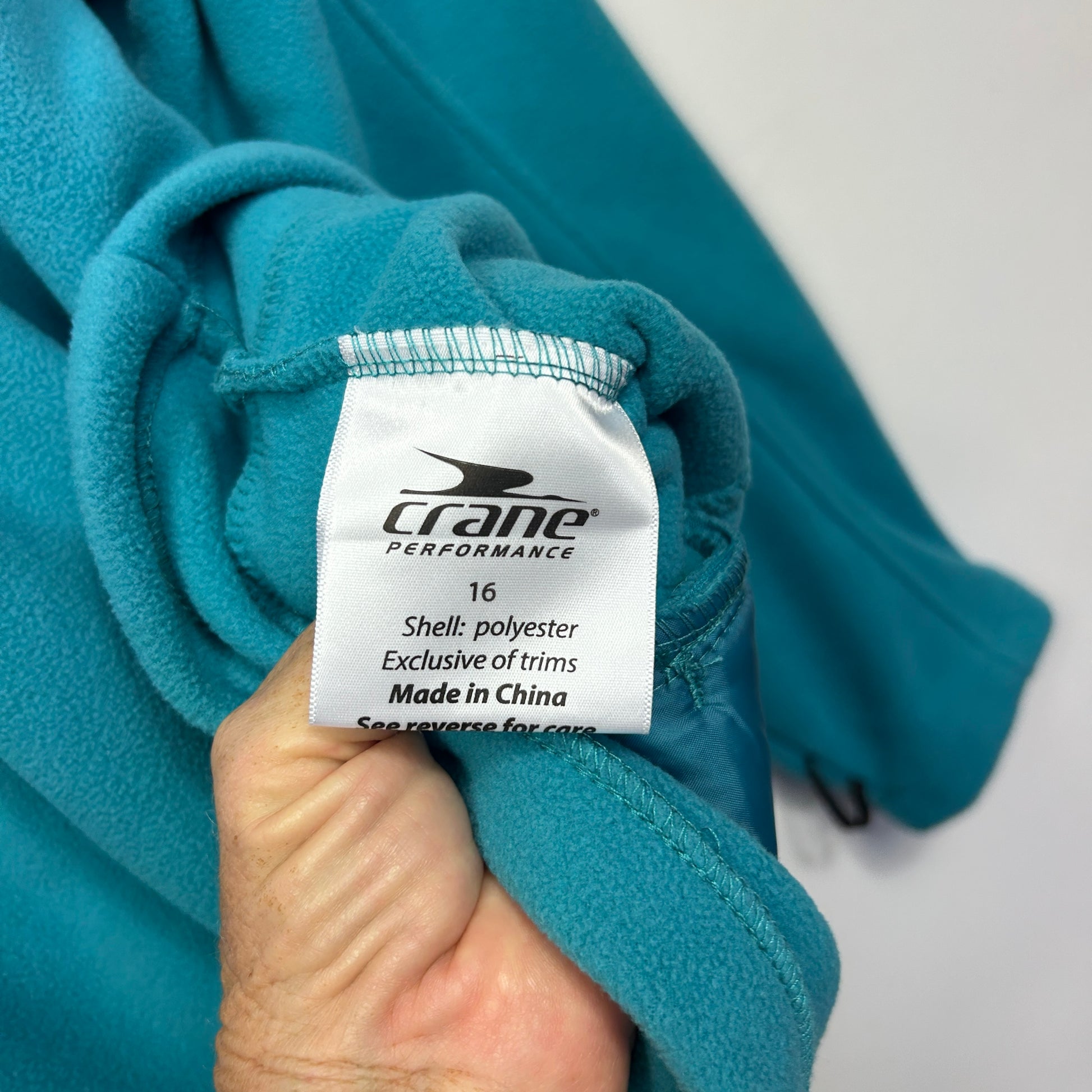 Teal fleece jacket label detail view