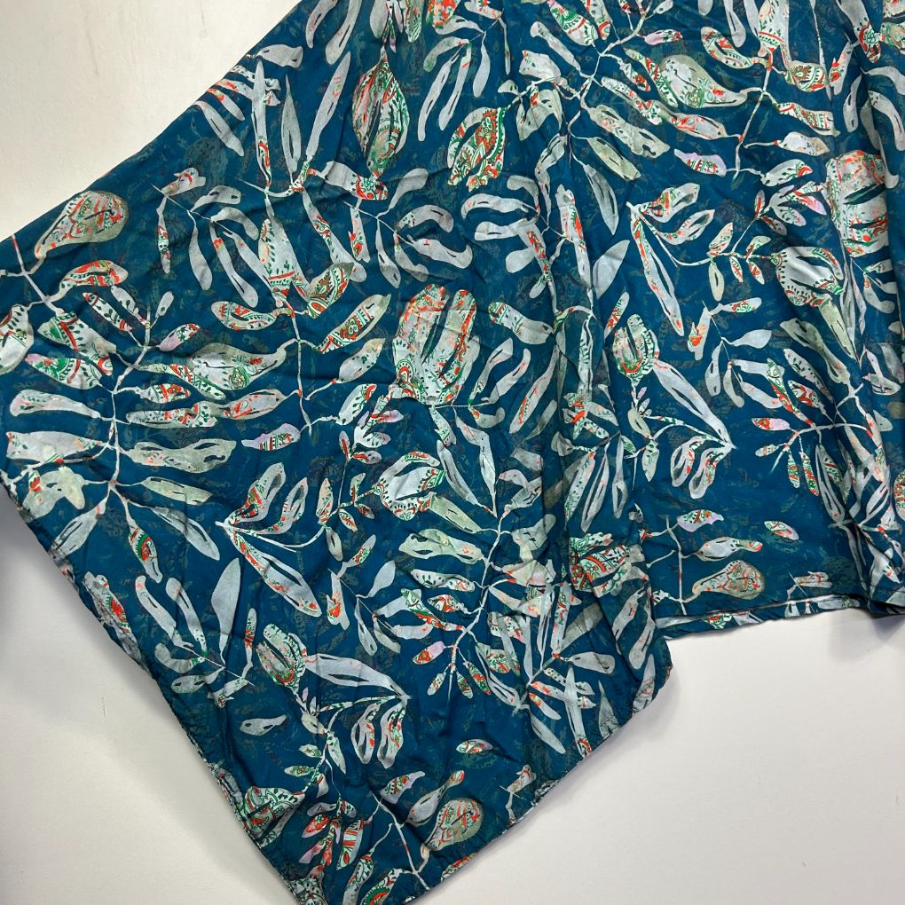 Blue fabric with botanical leaf pattern detail view