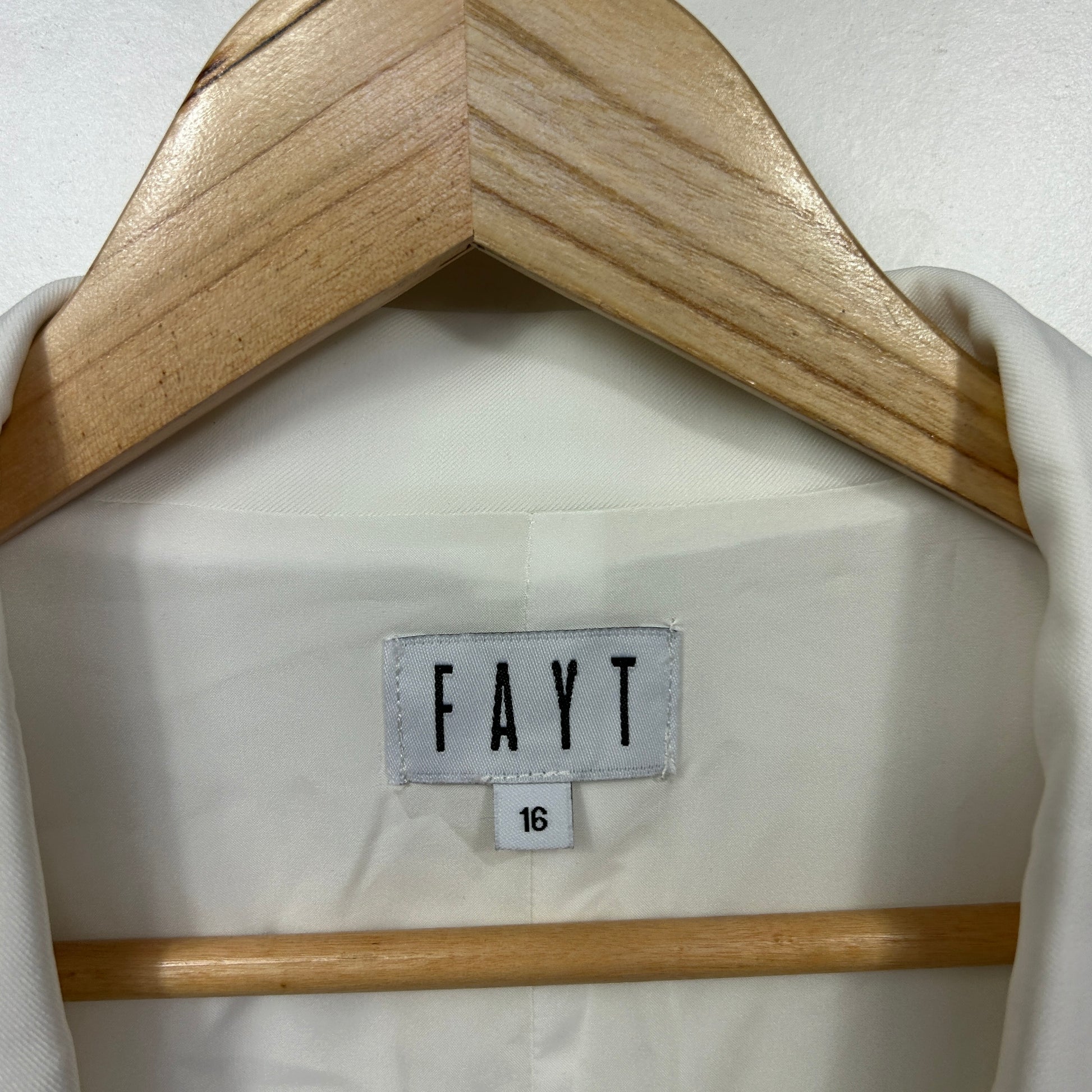 White blazer front view on wooden hanger