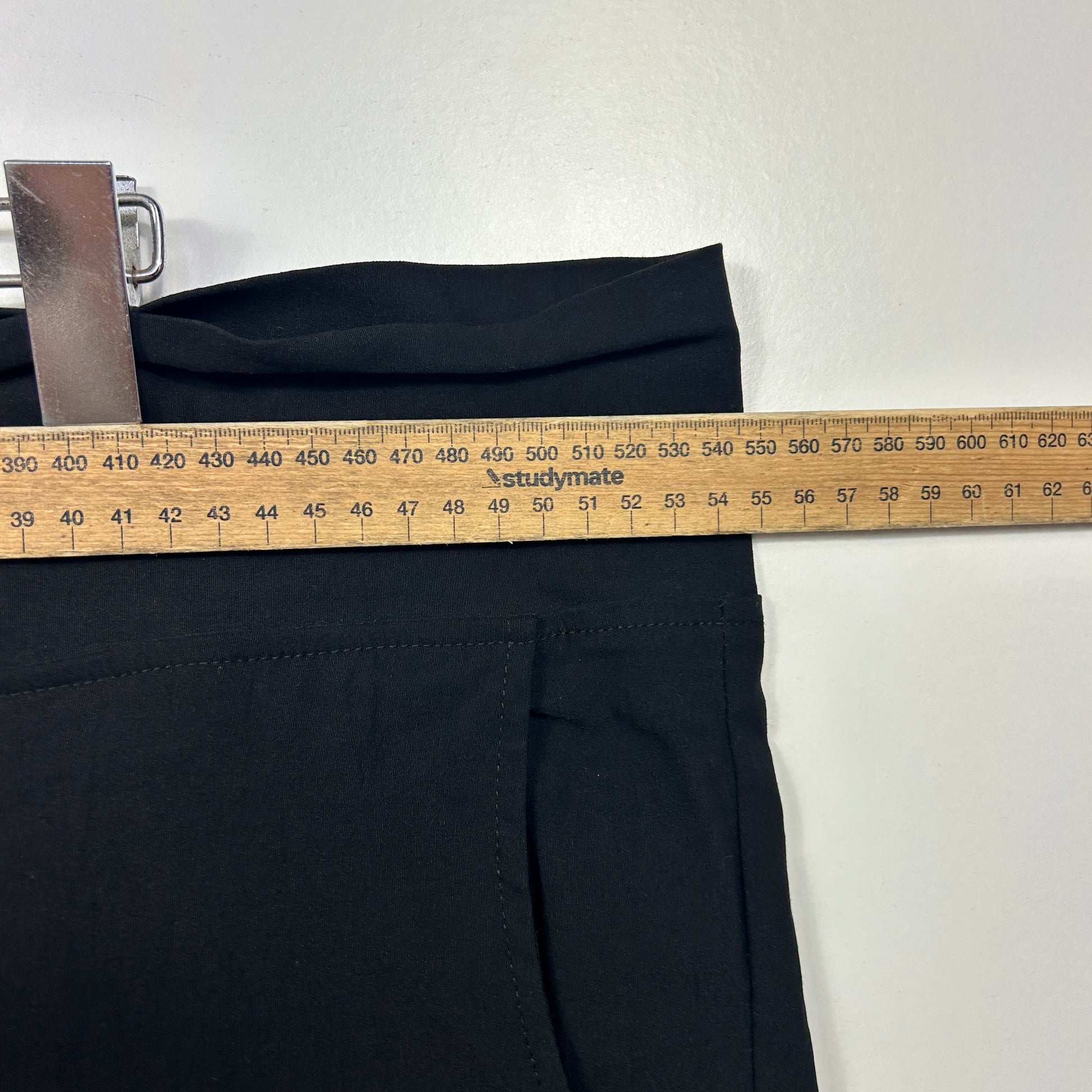 Black pants with measurement tape detail view
