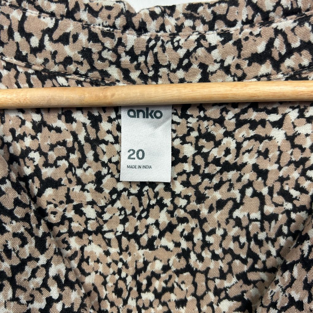 Black and cream speckled fabric swatch with size label detail view