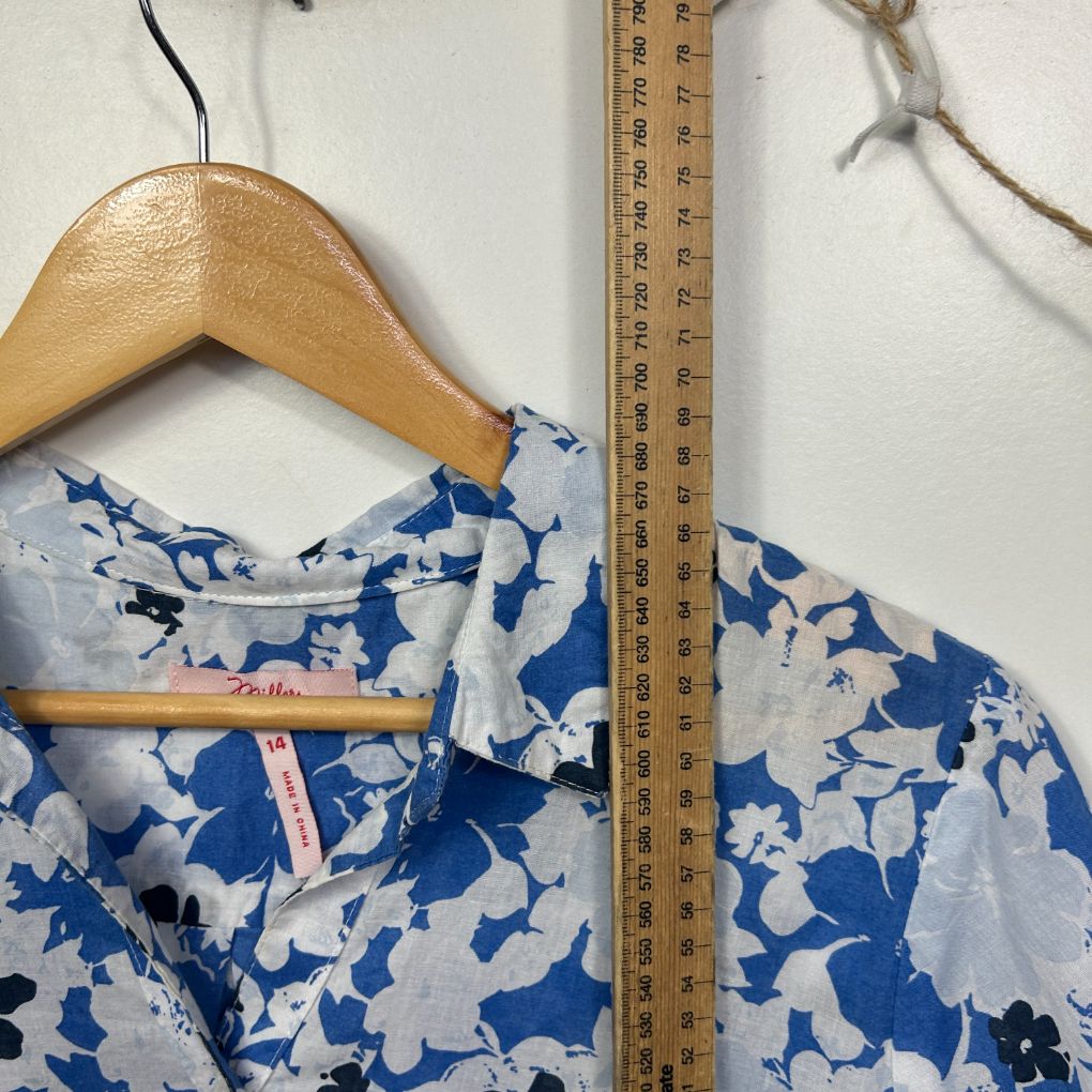 Blue and white floral top front view on wooden hanger with measuring tape