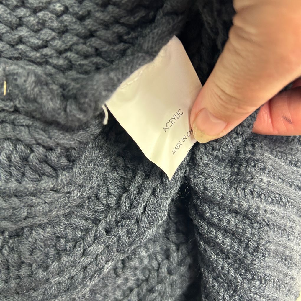 Grey knit sweater label detail view