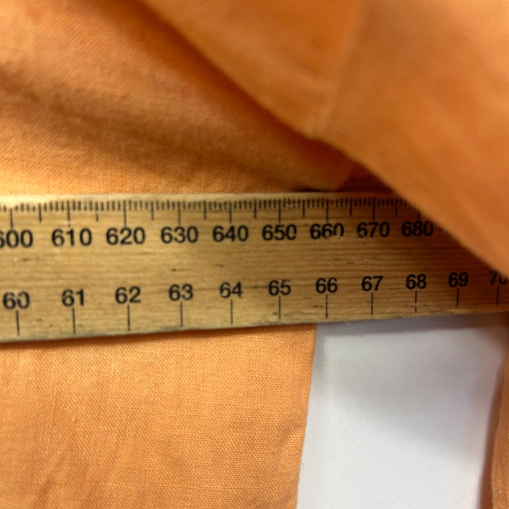 Orange fabric detail view with measuring ruler