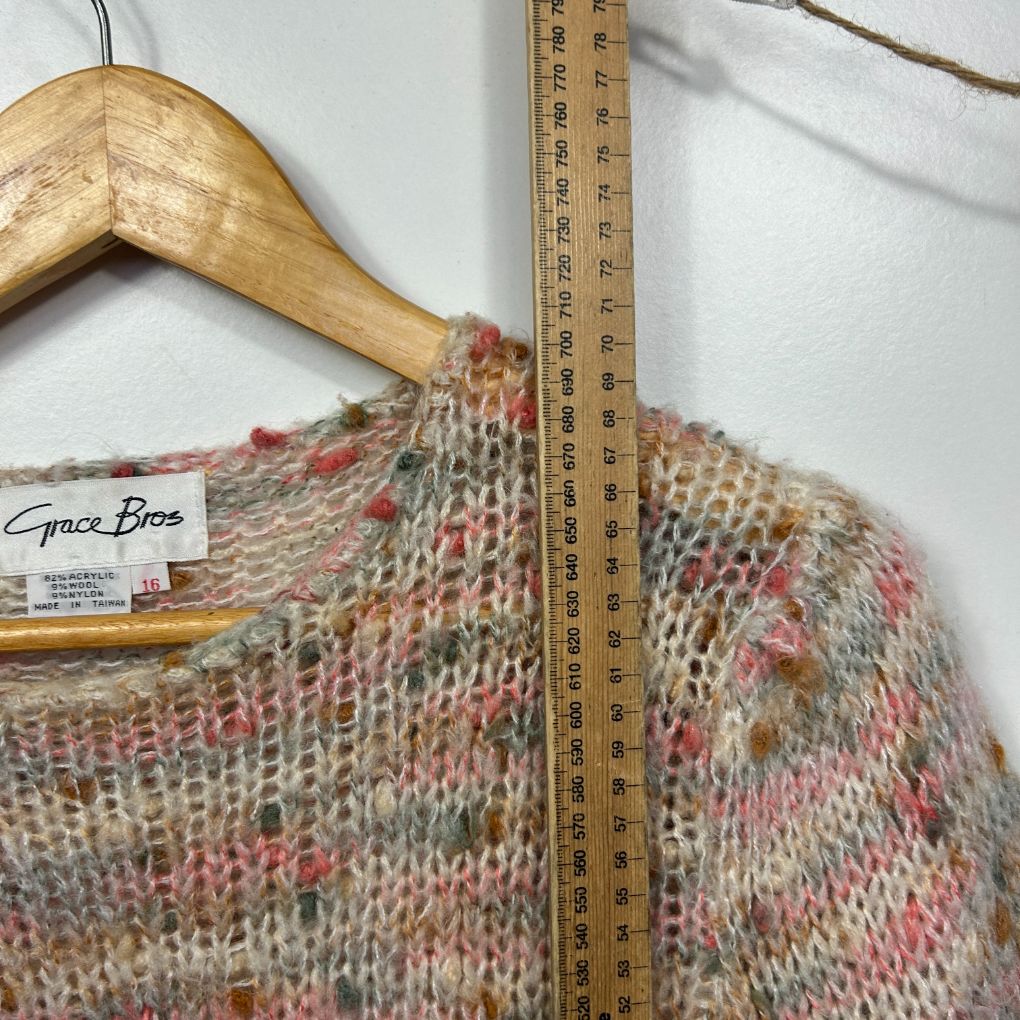 Beige knit sweater with pink and red speckled pattern detail view