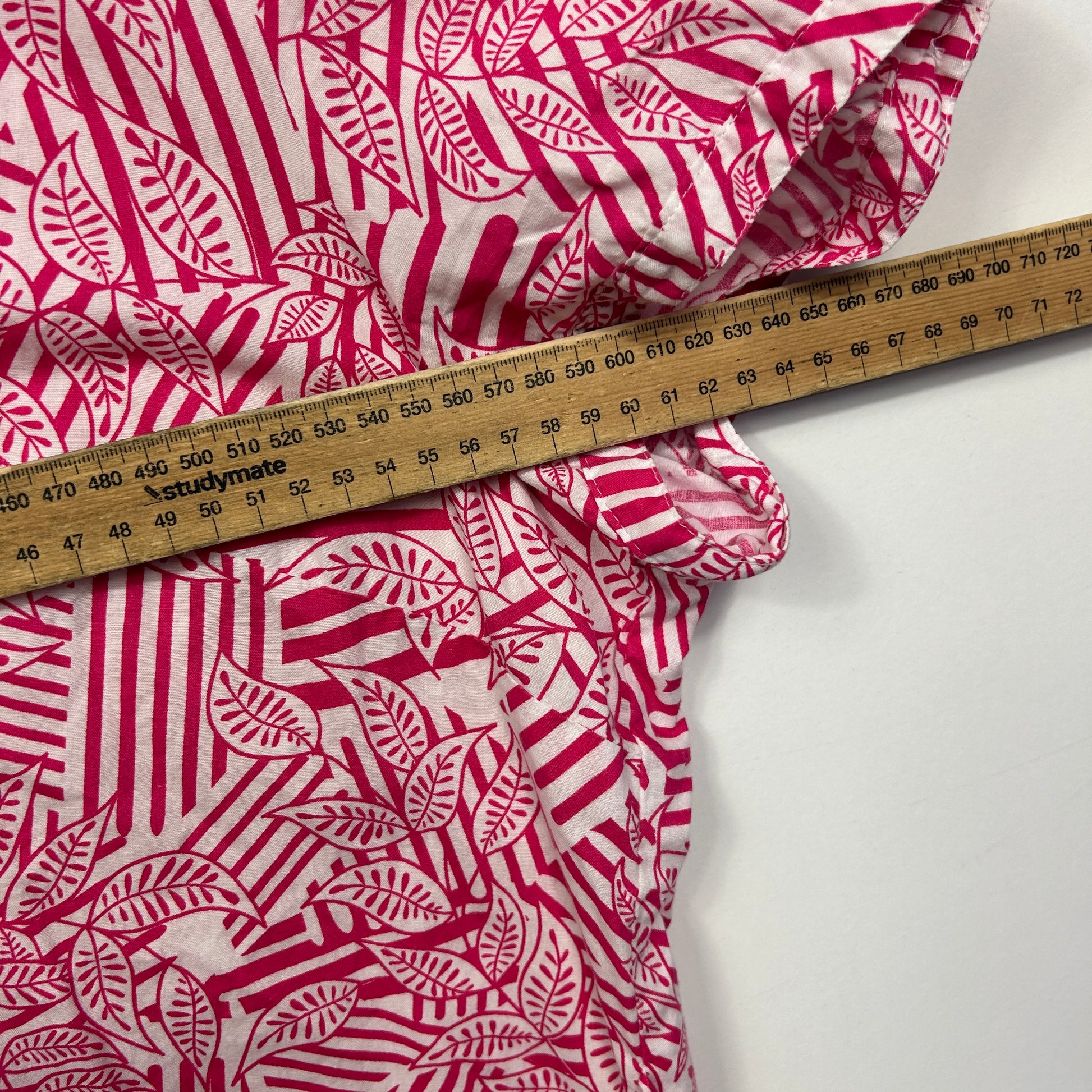 Pink and white patterned fabric with measuring tape detail view