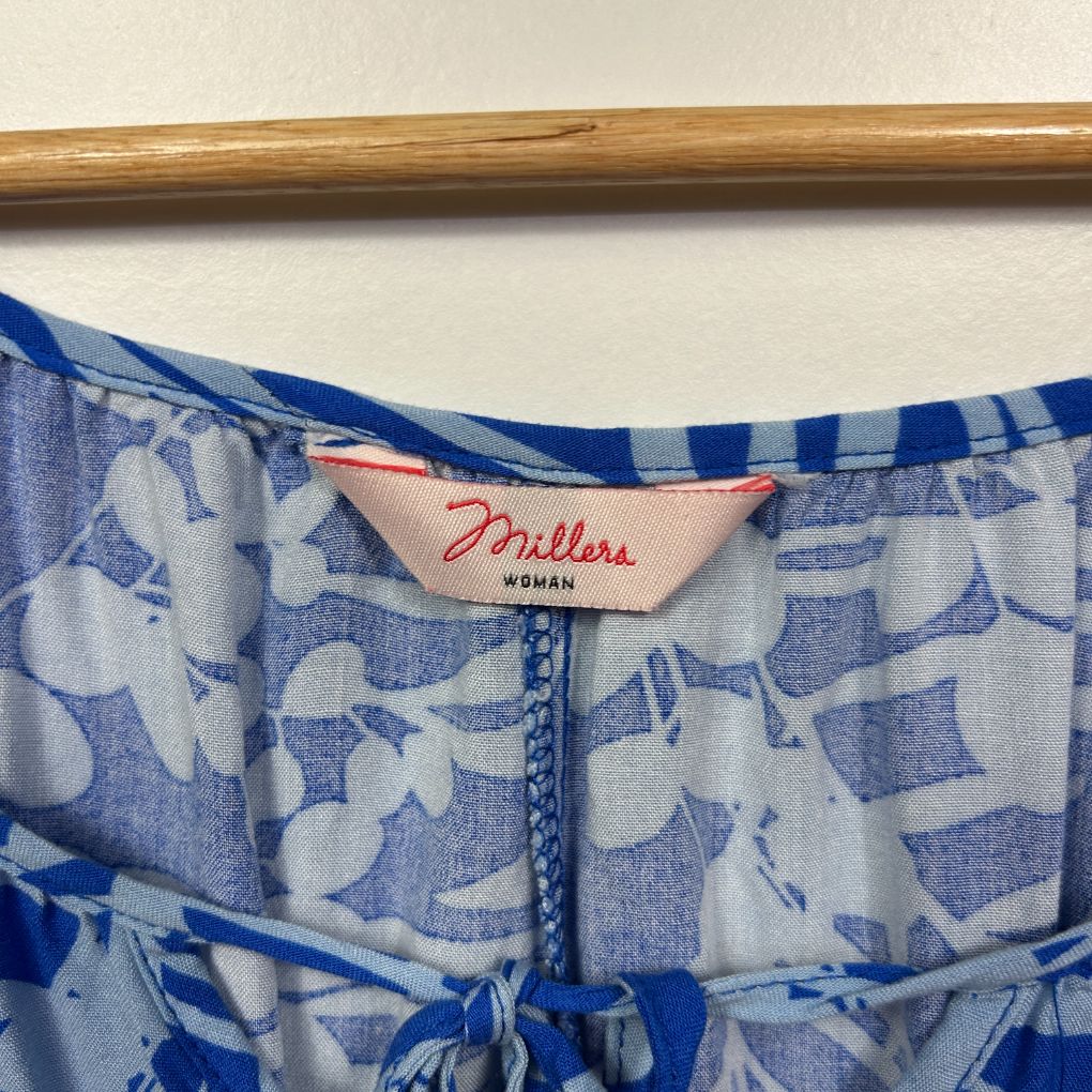 Blue and white floral dress detail view showing label and back neckline
