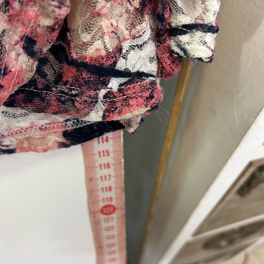 Pink and black patterned fabric detail view with measuring tape