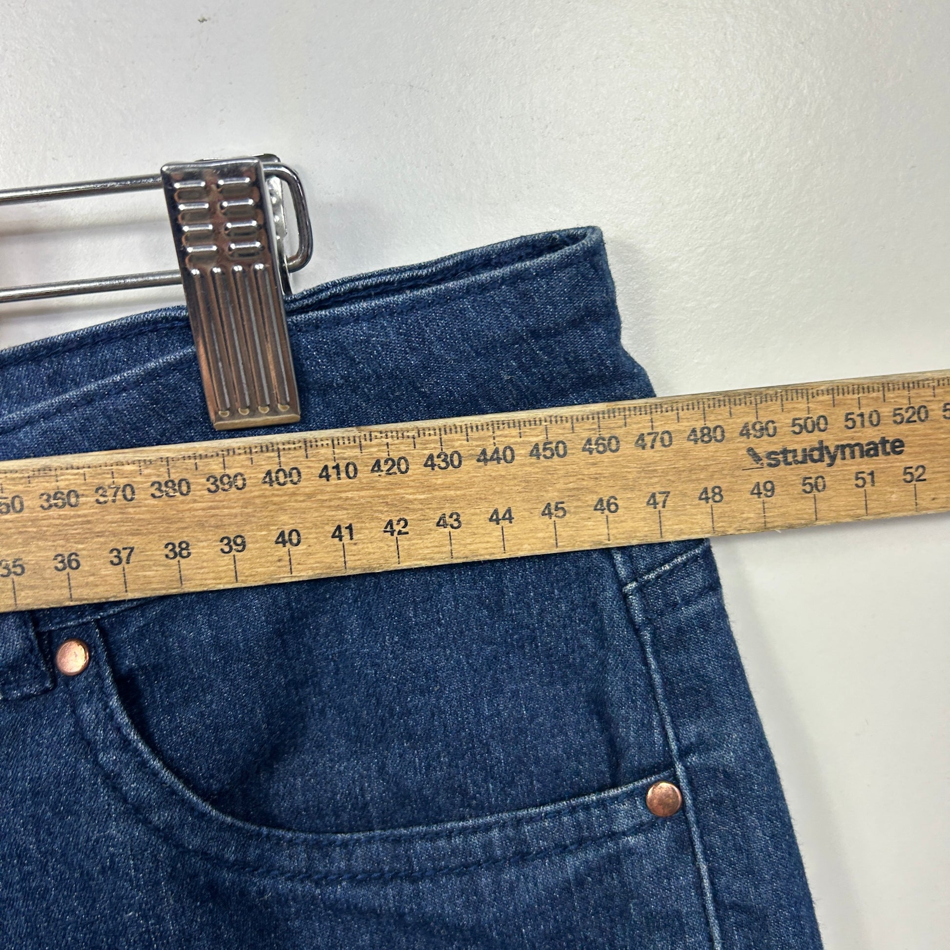 Dark blue denim jeans front view with measuring tape