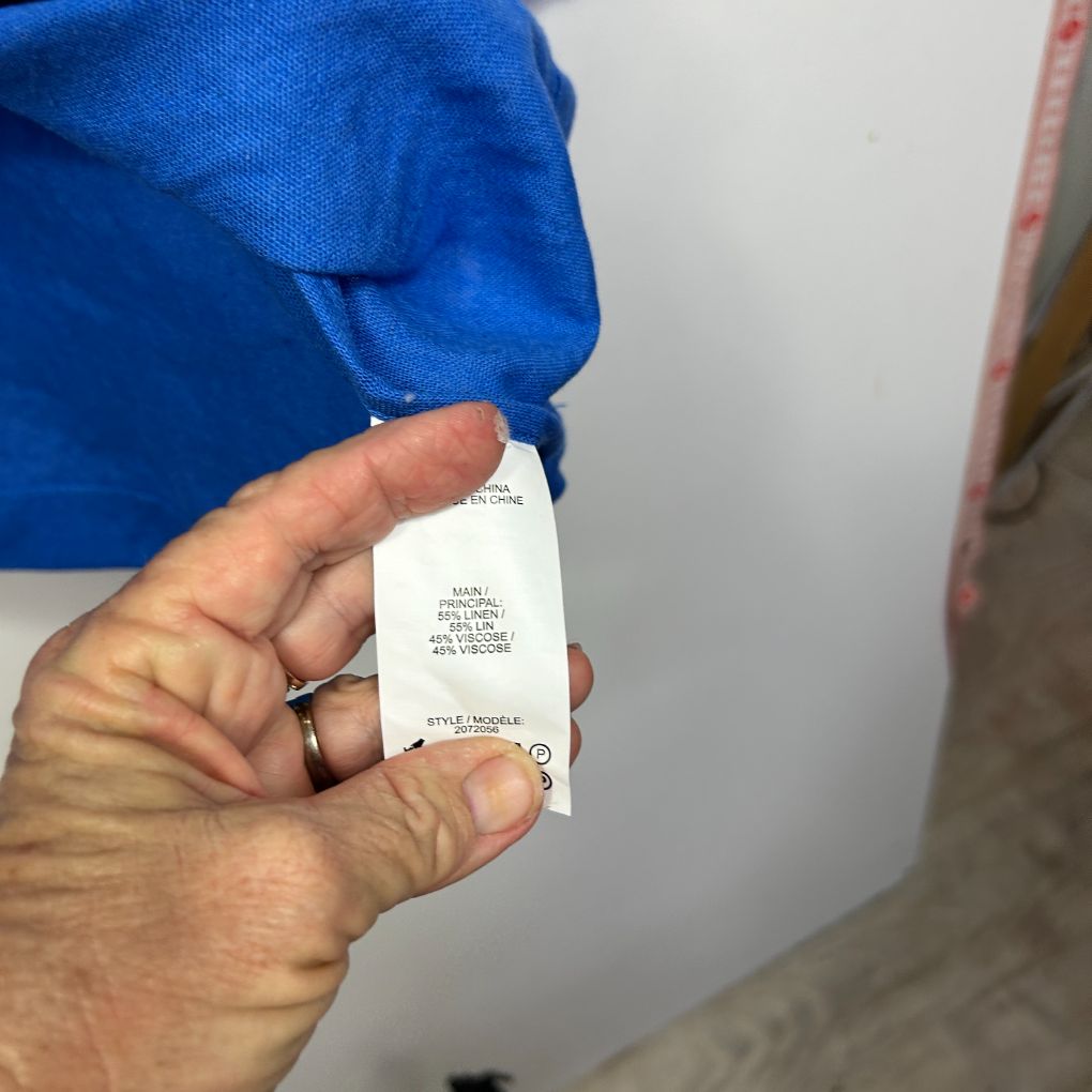 Blue garment with white care label detail view