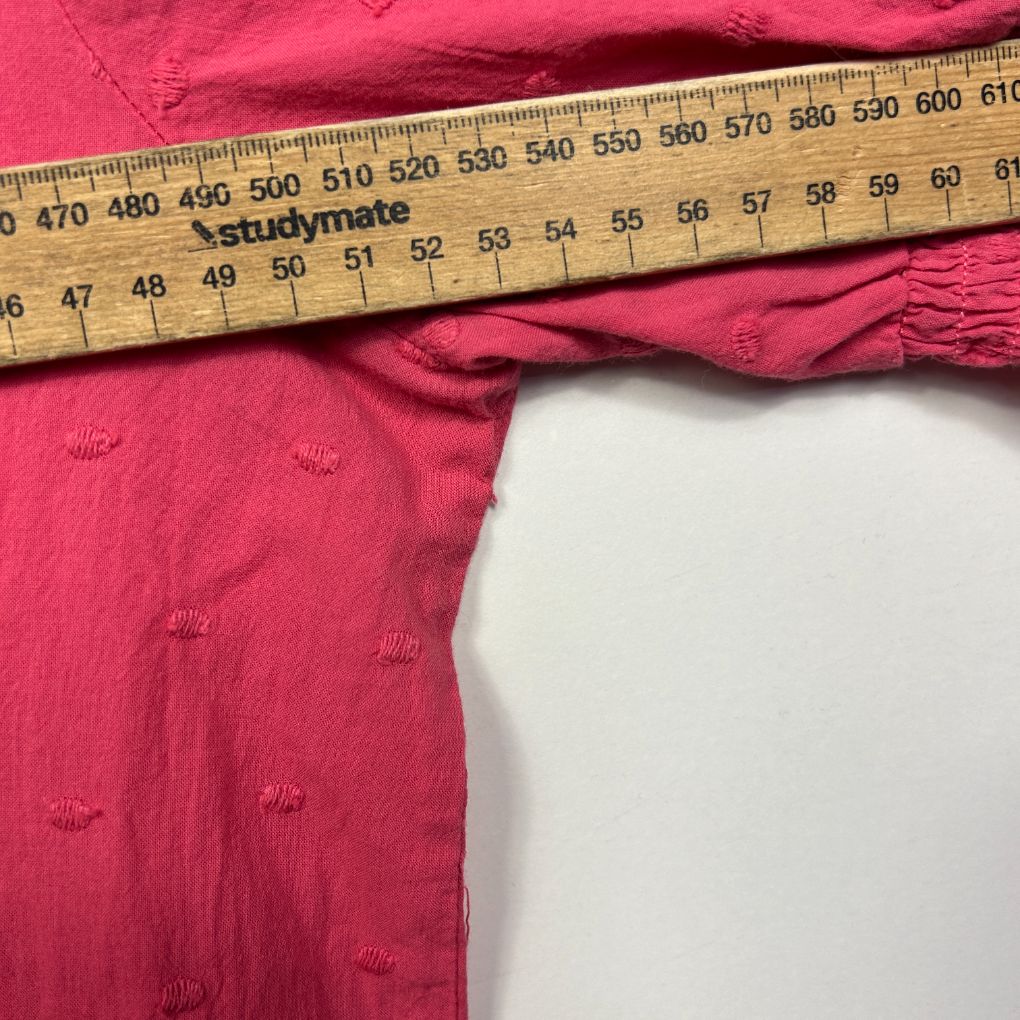 Pink textured fabric with measurement ruler detail view