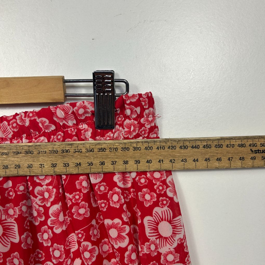 Red floral fabric with measuring tape detail view