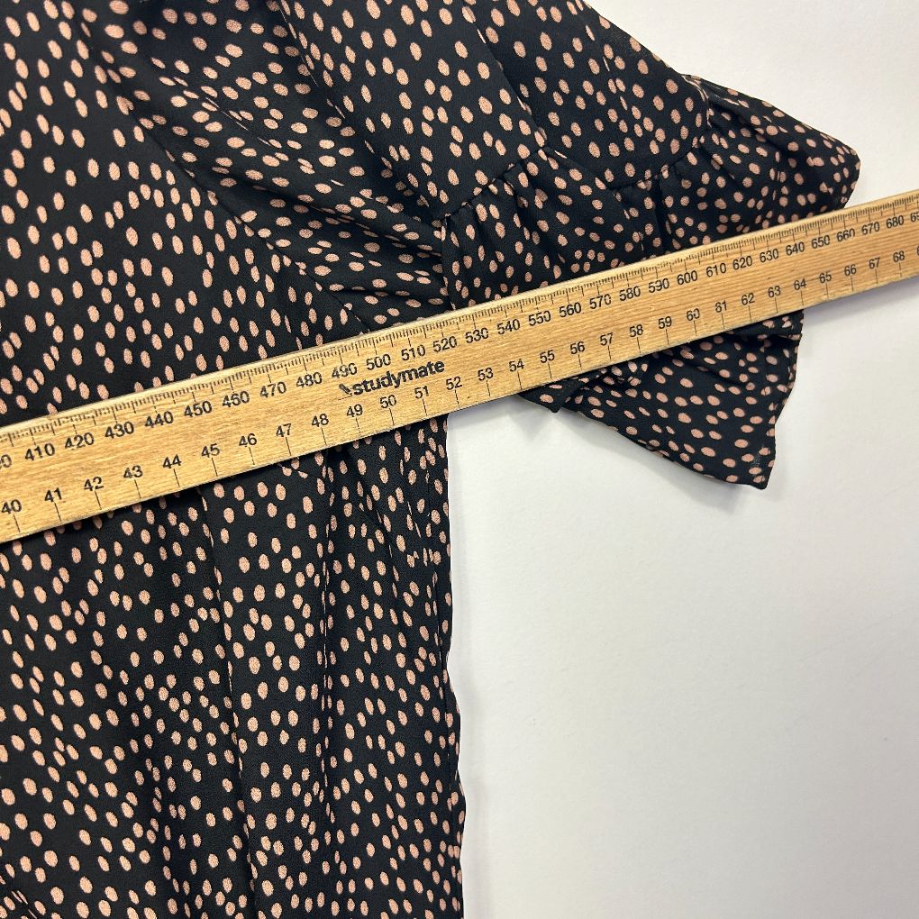 Black and cream spotted fabric detail view with measuring tape