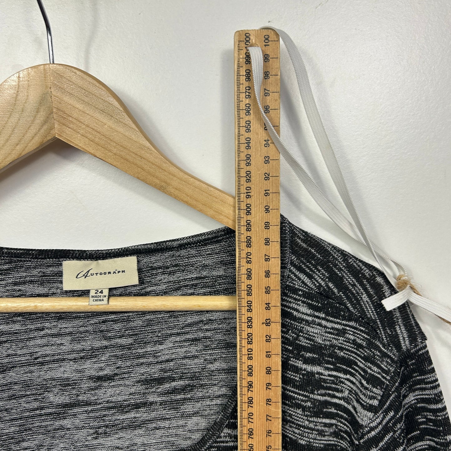 Grey marled tank top front view on wooden hanger with measuring tape