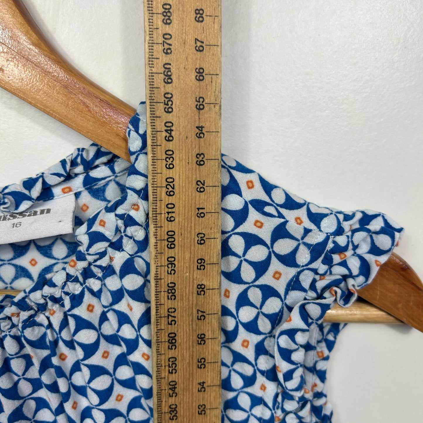 Blue and white geometric patterned short sleeve top front view with measuring tape