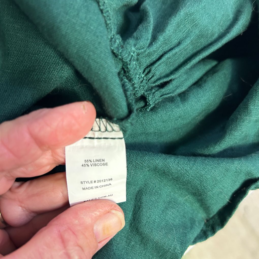 Green linen shirt label detail view
