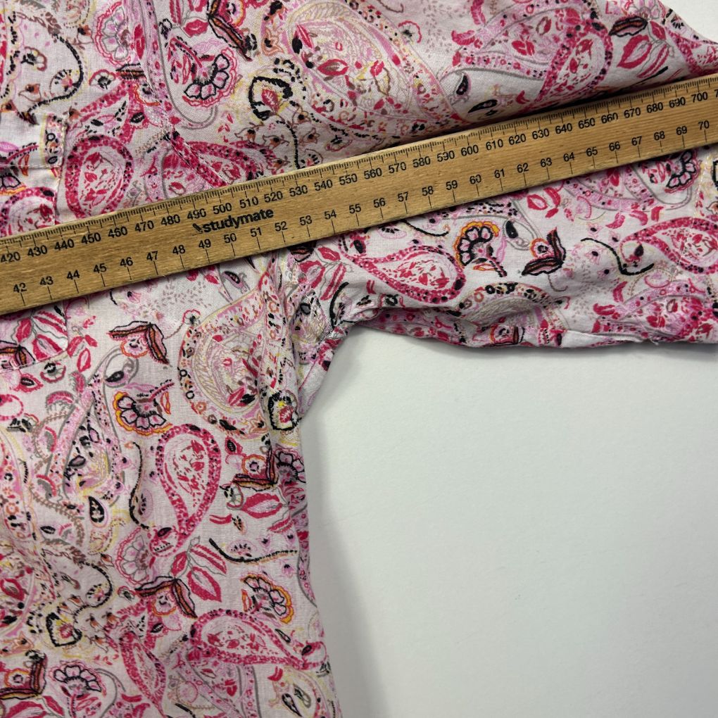 Pink floral fabric detail view with measuring tape