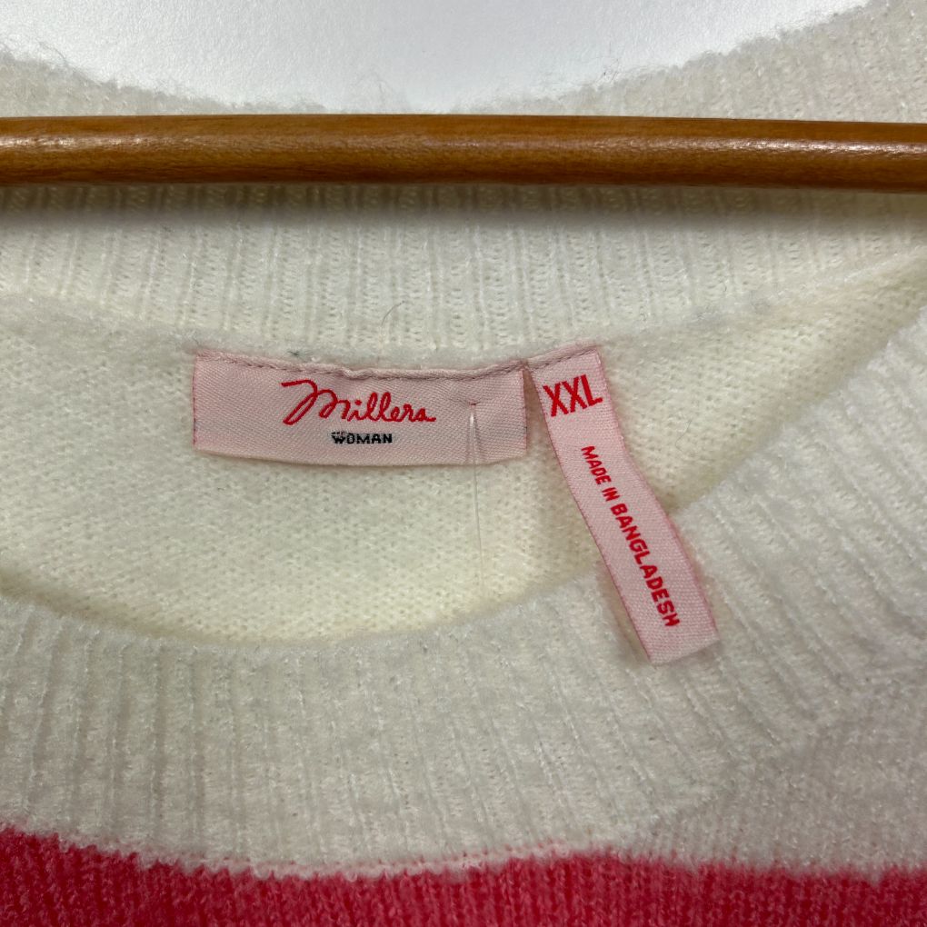 Cream and red knit sweater label detail view