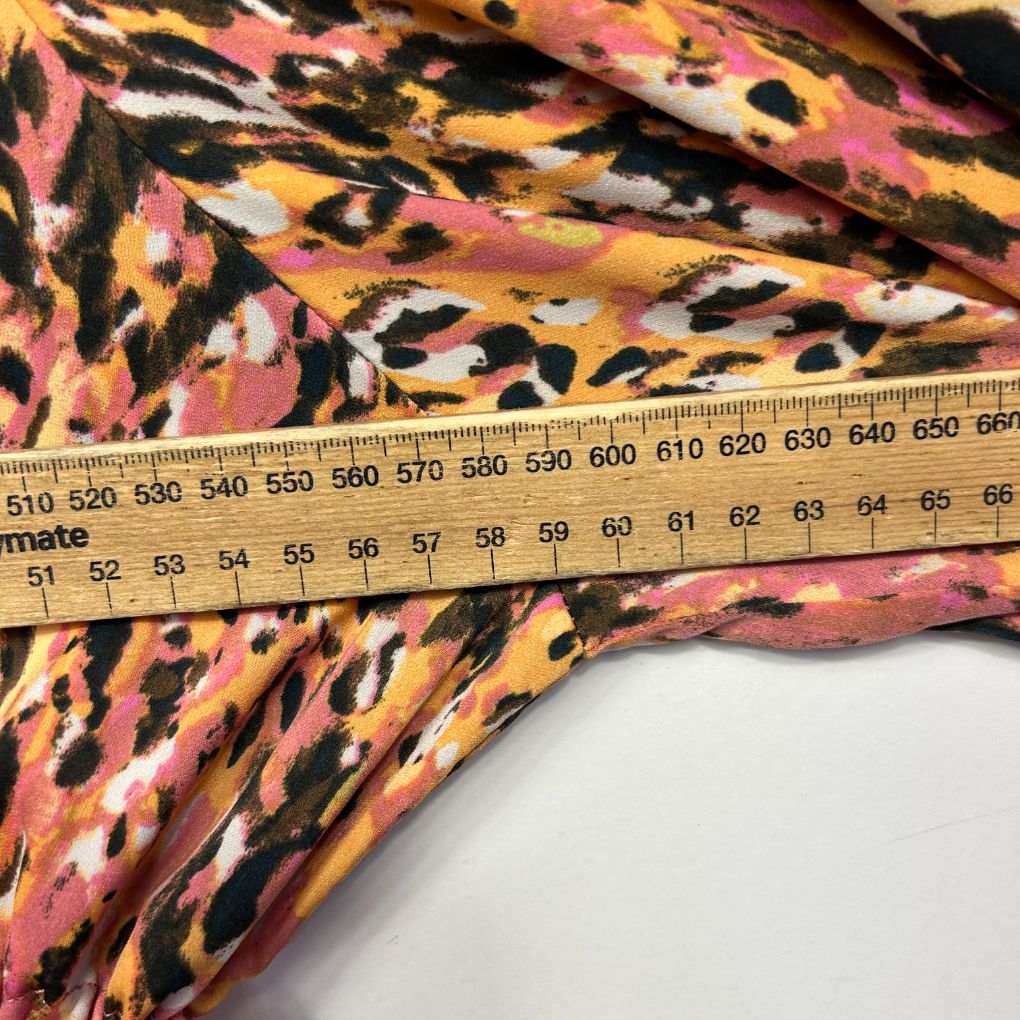 Pink and black leopard print fabric detail view with measuring tape