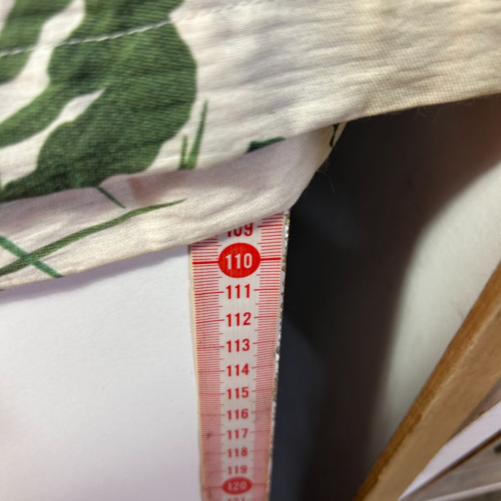 Green and white floral fabric detail view with measurement scale