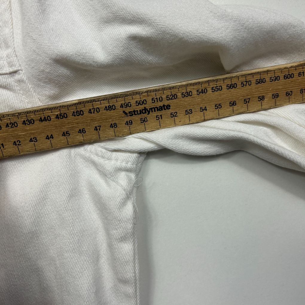 White garment detail view with measuring tape